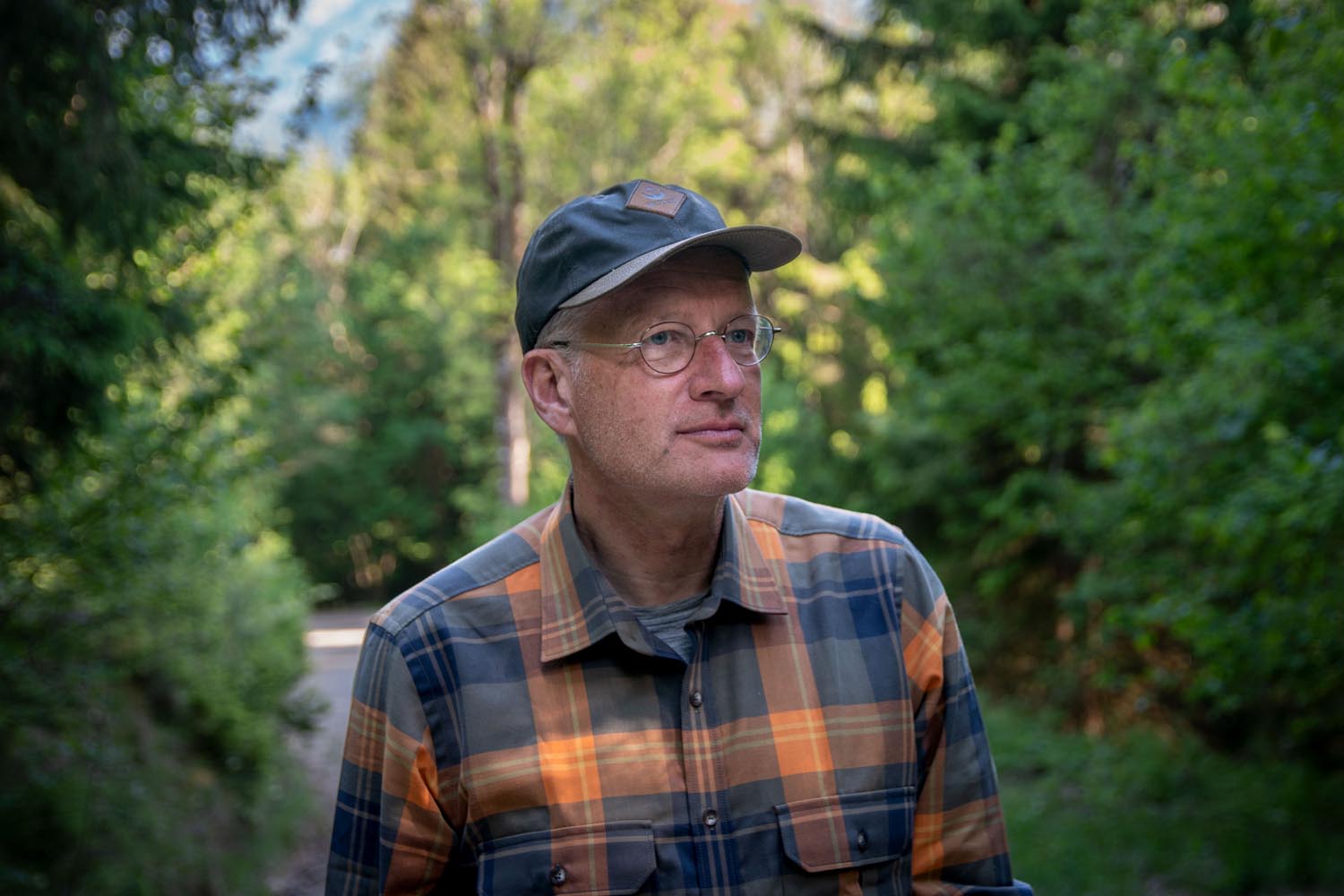 Mann im Wald mit Kappe und Karohemd
