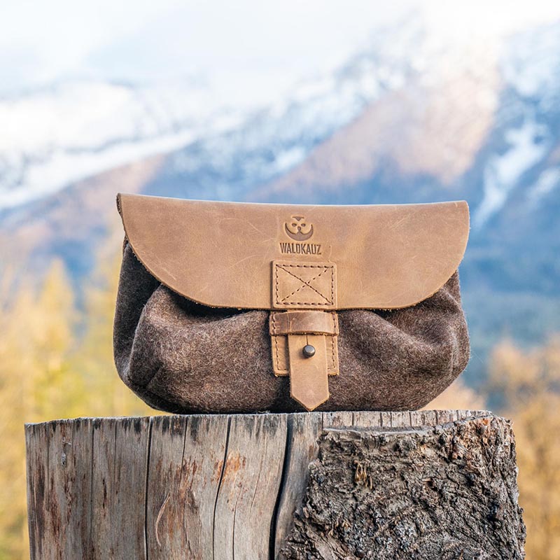 Gürteltasche mit Lederdeckel auf Baumstumpf