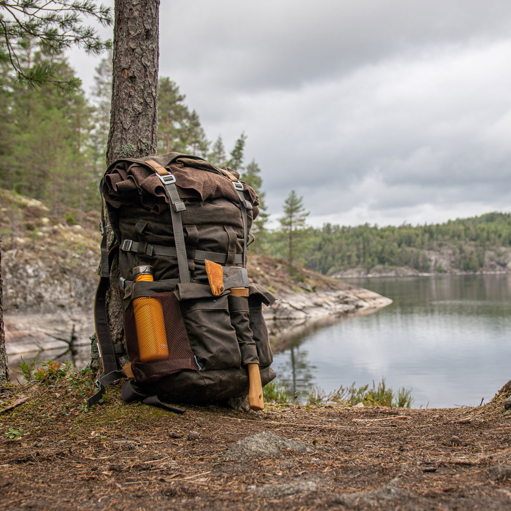Rucksack Bushmann an Kiefer geleht vor schwedischem See